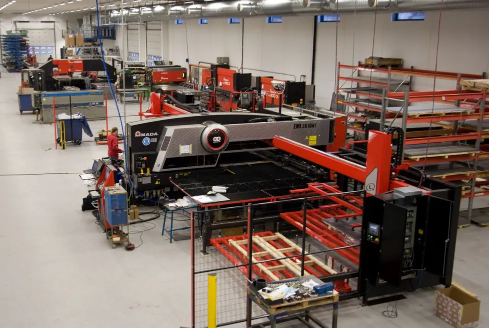 A large red Amada CNC sheet-metal machine on the floor of Vendanor's metal fabrication factory.