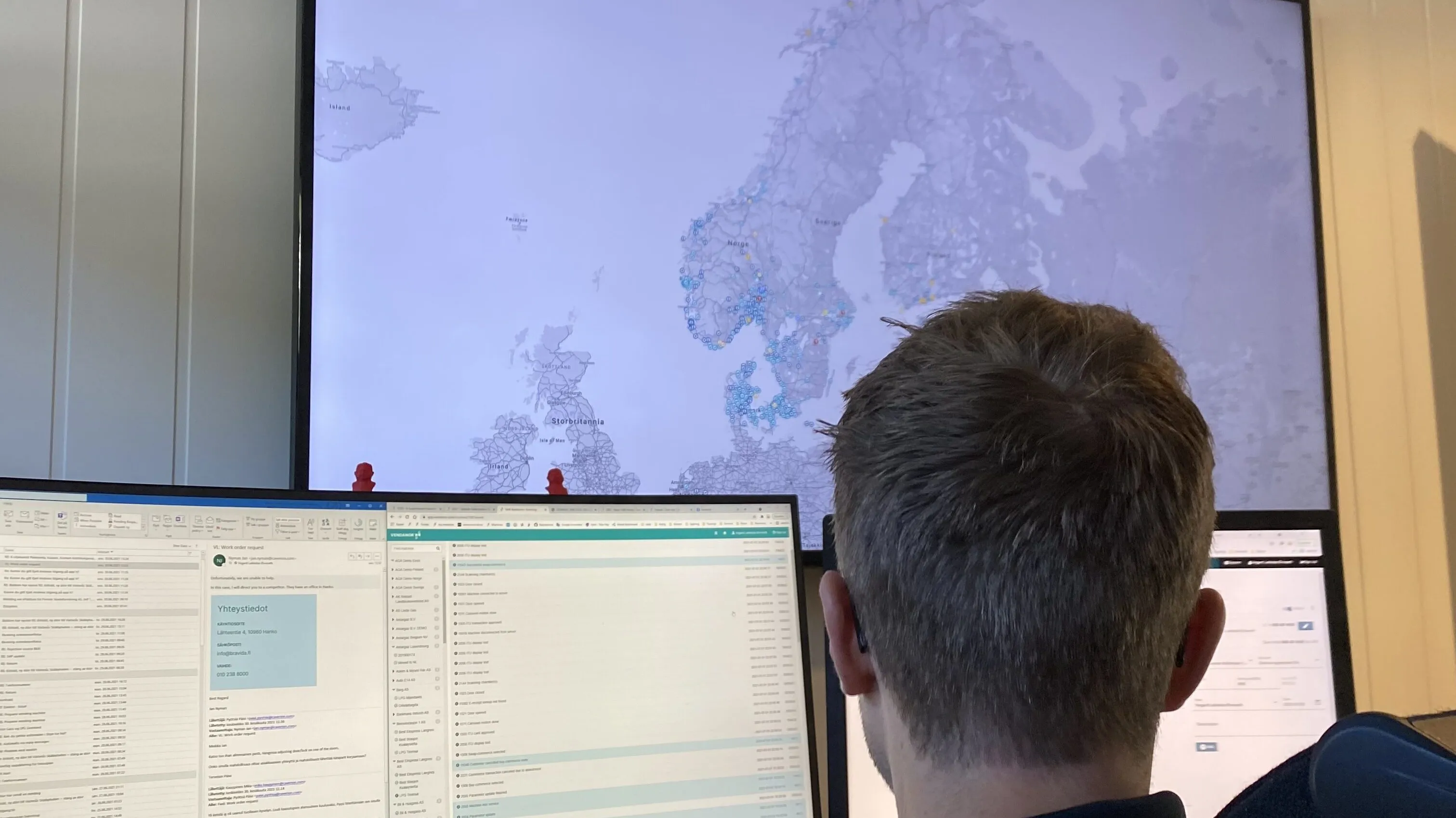 Vendanor employee at a desk viewing a large map of Europe and dashboards on multiple screens.