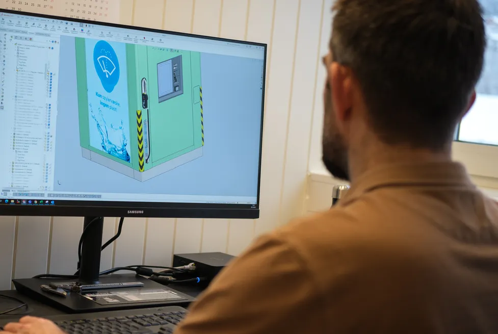 A Vendanor engineer works at a computer showing a CAD model of a Washer Fluid Dispenser on screen.