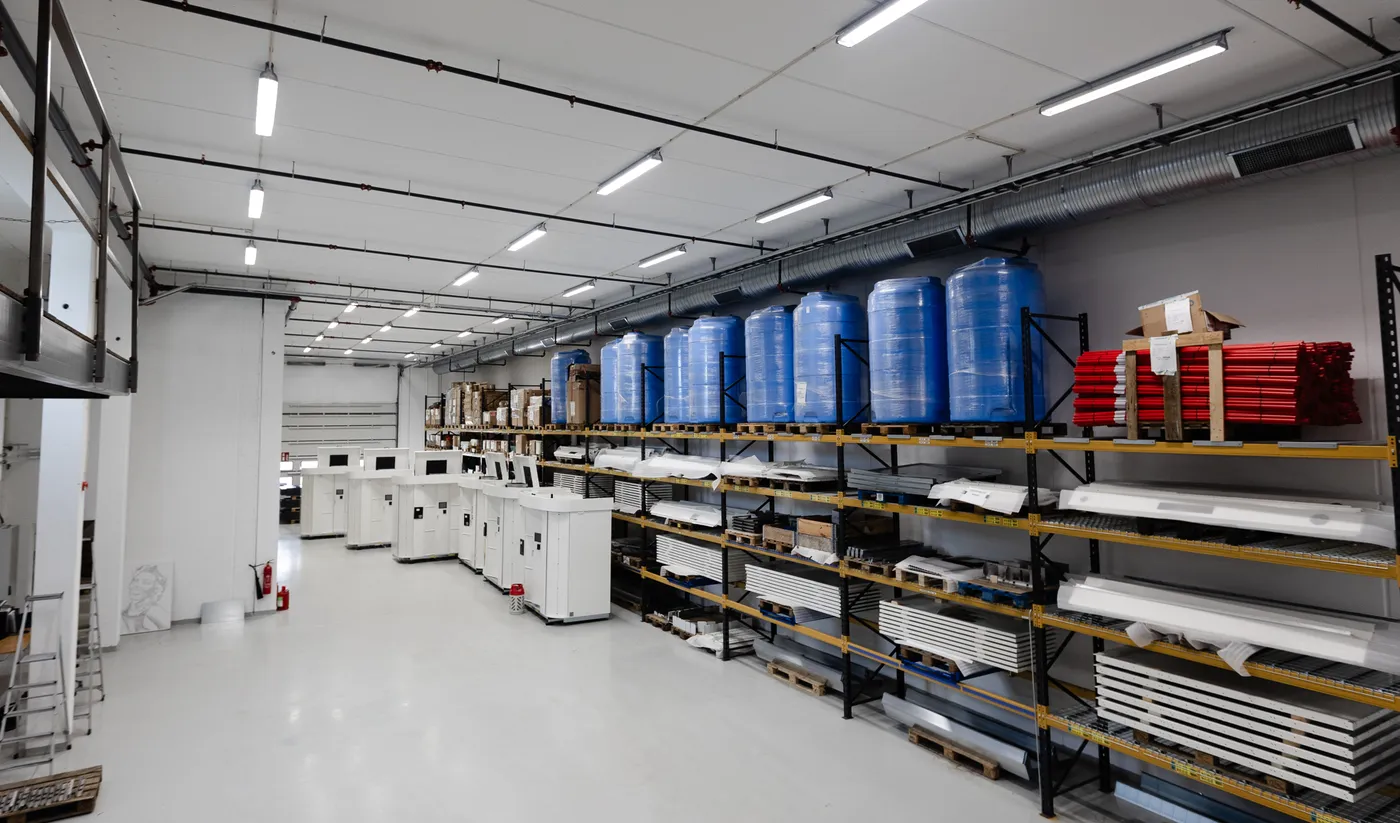 Vendanor's modern production facility with washer fluid tanks, components and parts stored on shelving along the wall.