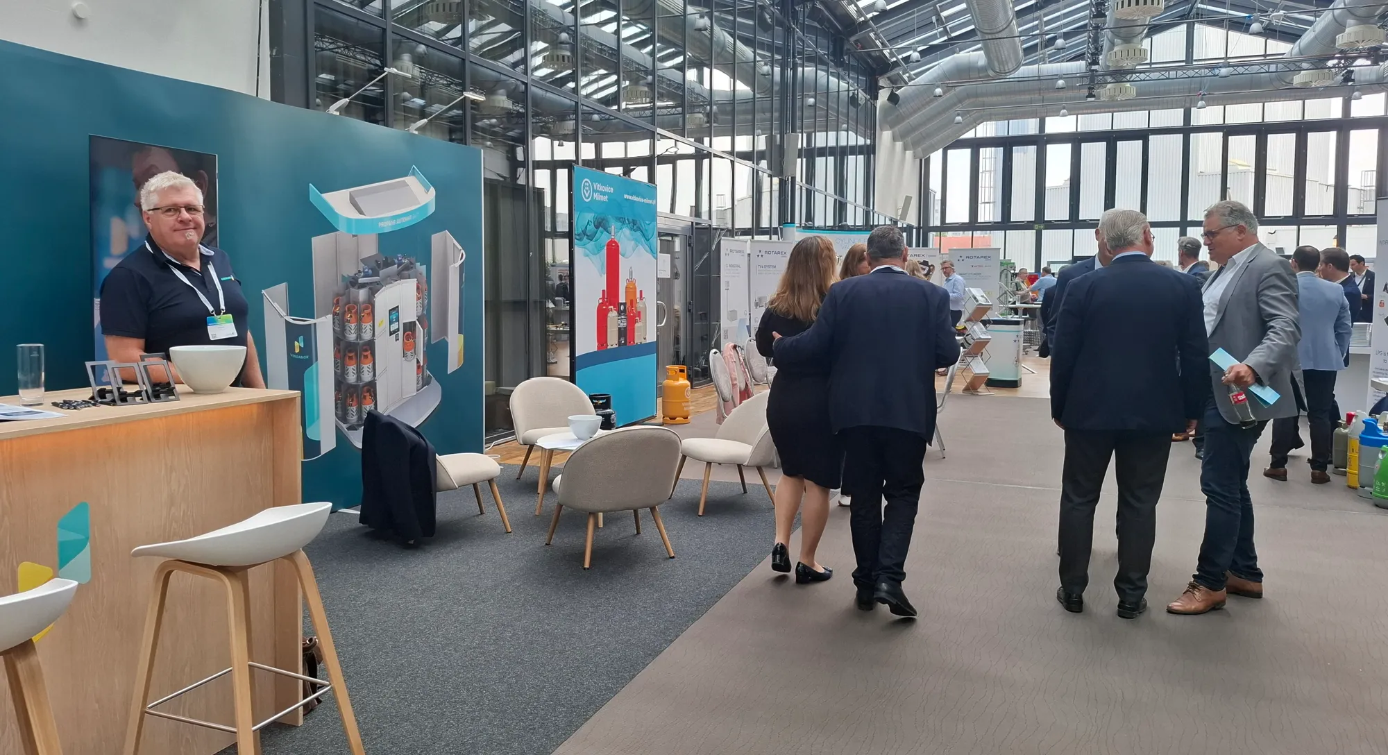 Vendanor exhibition stand with seating area and product graphics in a glass hall in Berlin.