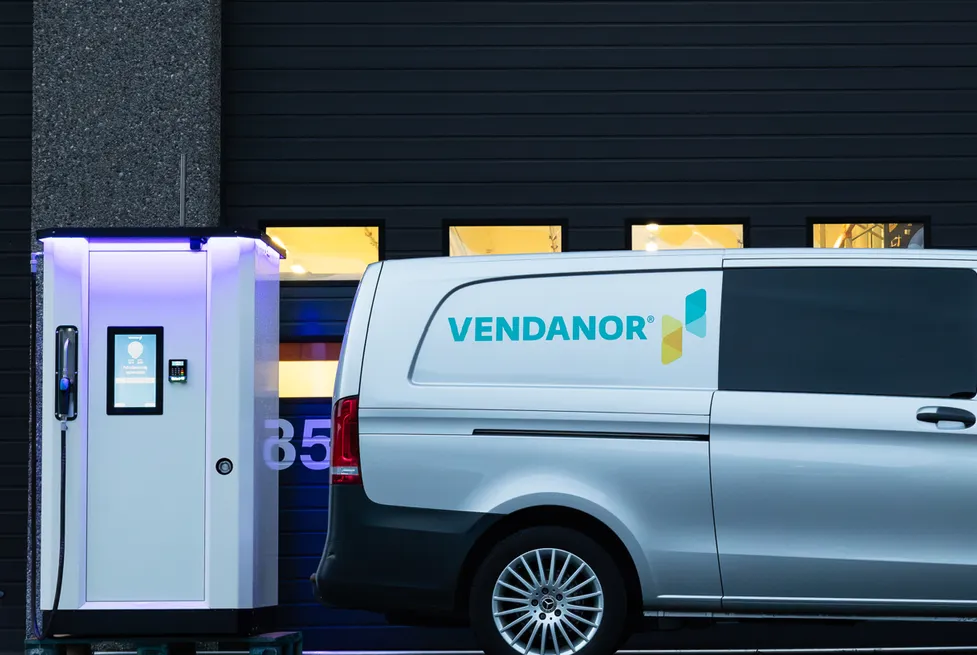 Compact Vendanor Washer Fluid Dispenser next to a branded Vendanor service van outside a building.